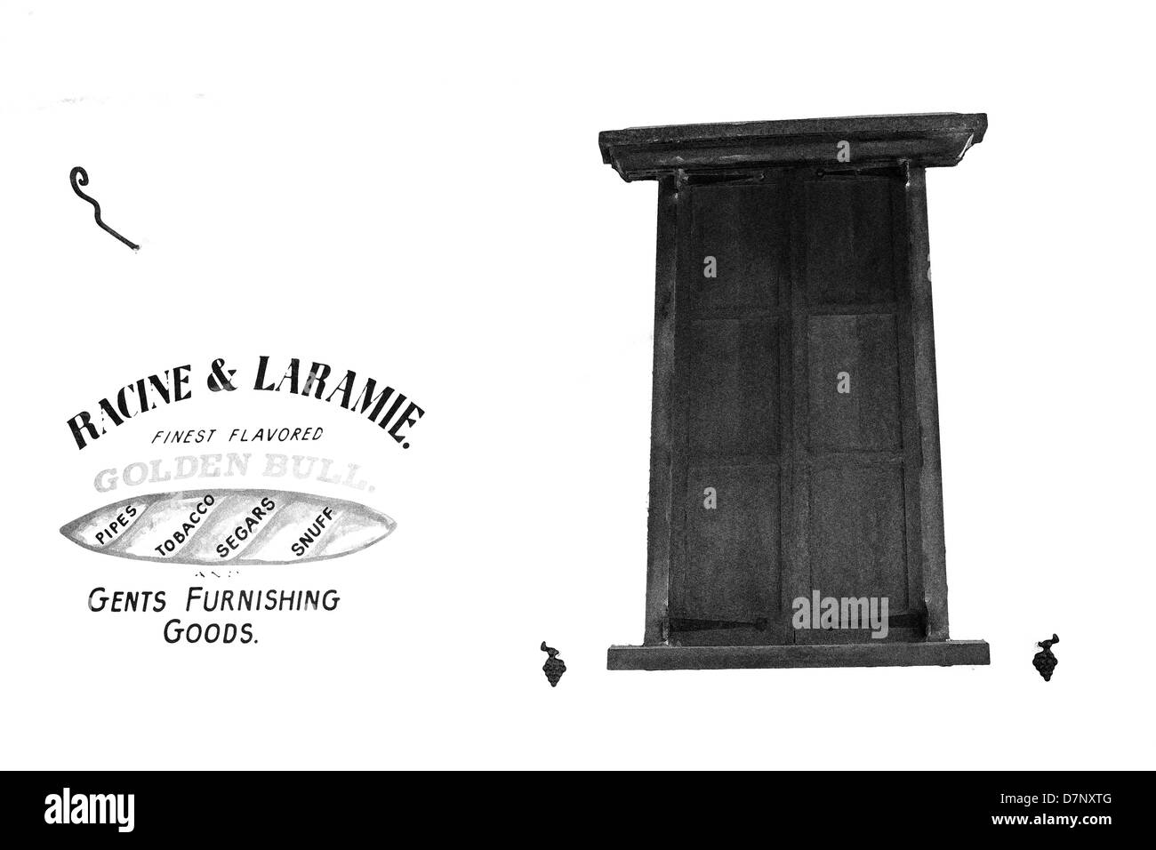A black and white high key image of a shuttered window and shop sign painted on the wall. Stock Photo