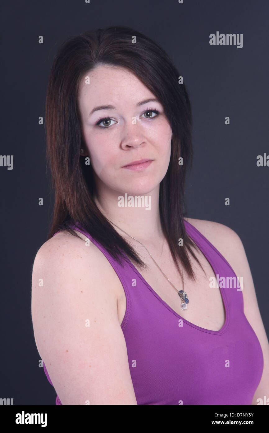 Beautiful young woman wearing a purple singlet against a black back ground Stock Photo