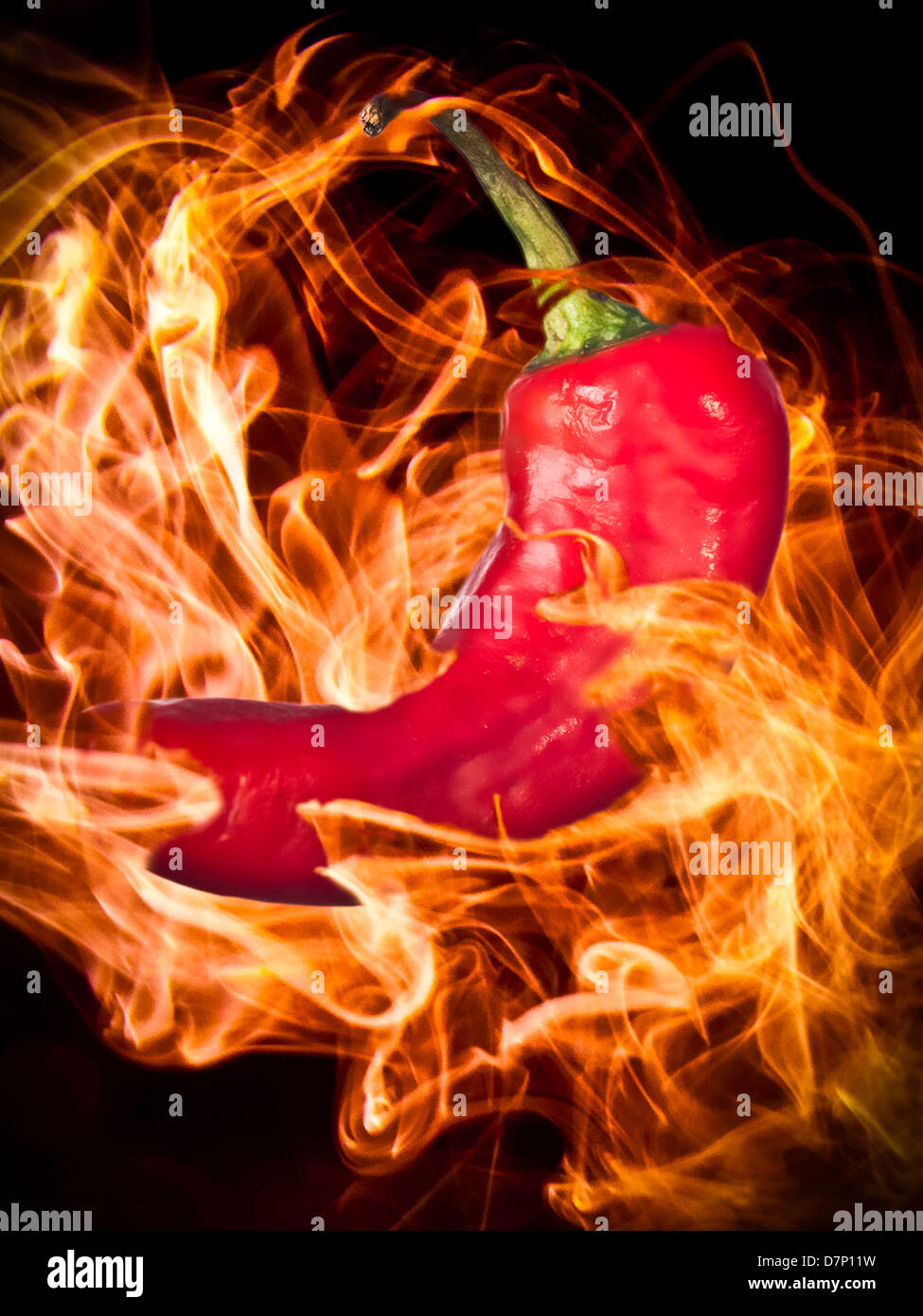 Creative image of a chilli pepper surrounded by flames. Stock Photo