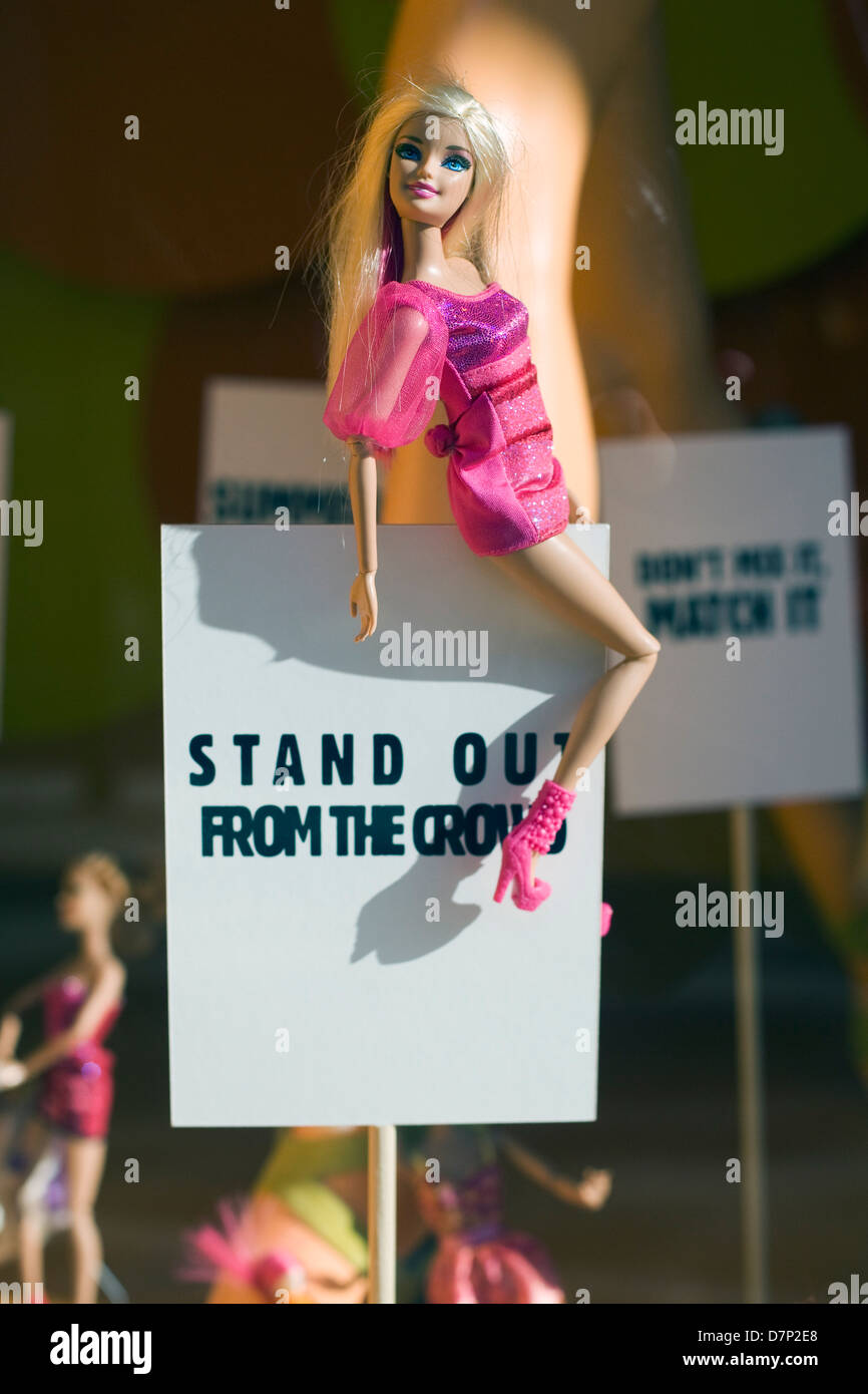 Advertisement in a store window Doll of a sign 'Stand out from the crowd' Stock Photo