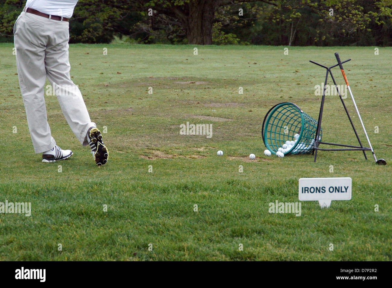 A Golfer practices at a golf course driving range Stock Photo Alamy