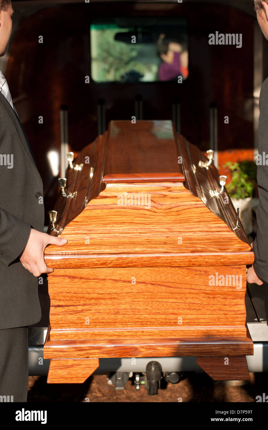 Dolor - Funeral with coffin on a cemetery, the casket carried by coffin bearer Stock Photo