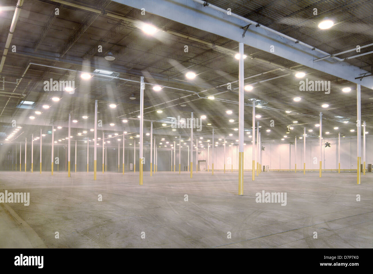 Large Empty Dusty Warehouse With Lights Shining Through Dust Stock