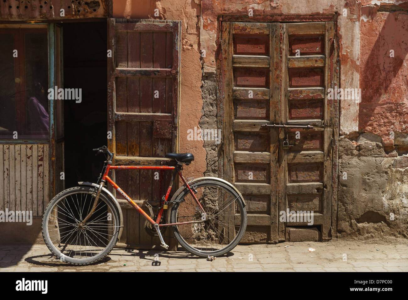 Marrakesh in the Kessabine Souk. Bicycle and old shop with wooden doors. Stock Photo