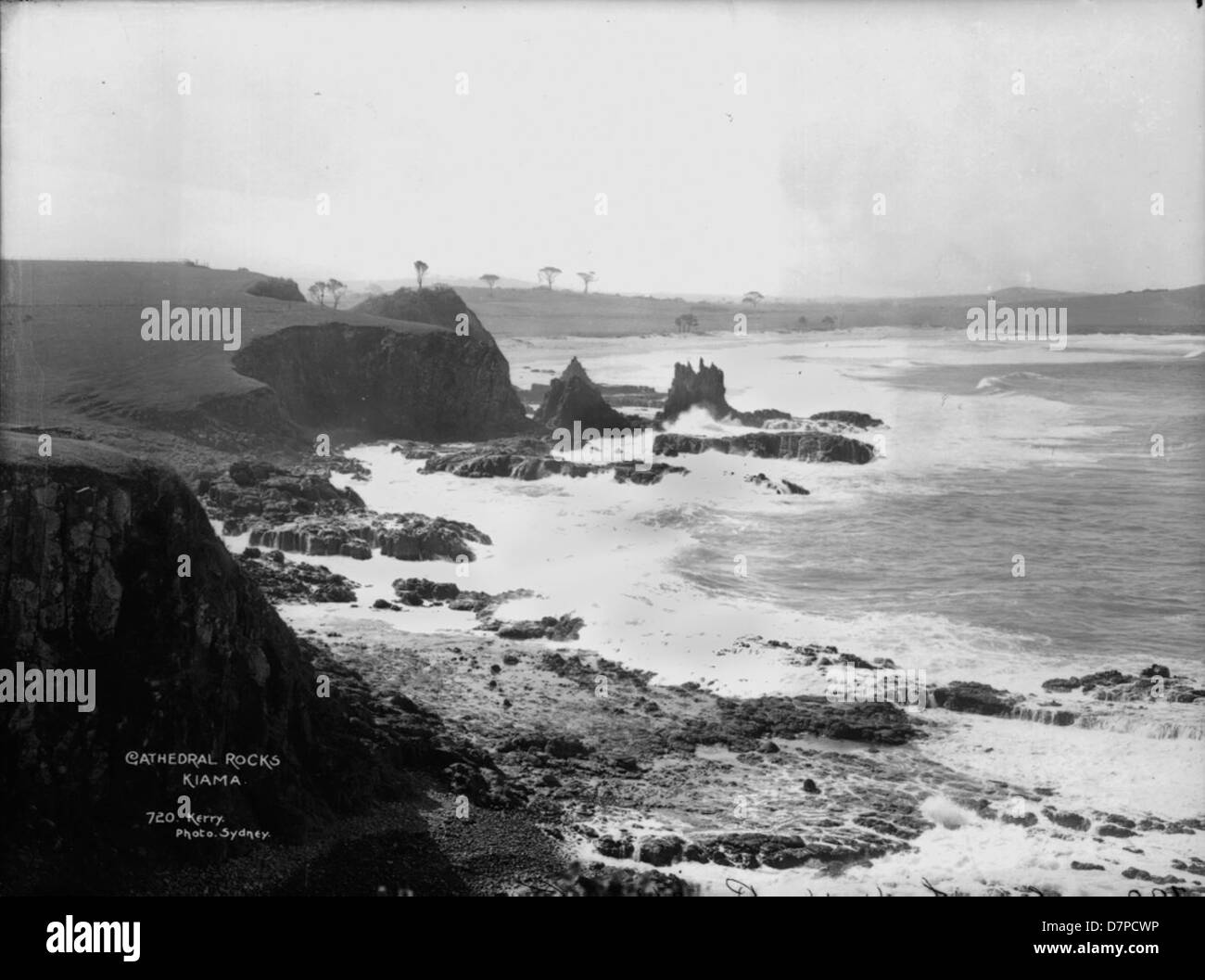 This black-and-white photograph captures the Cathedral Rocks in Kiama, Australia, showcasing the rugged coastline and dramatic cliffs of this iconic natural landmark. Stock Photo