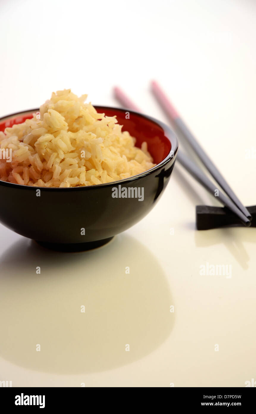 Bowl of rice with chopsticks on a white table Stock Photo