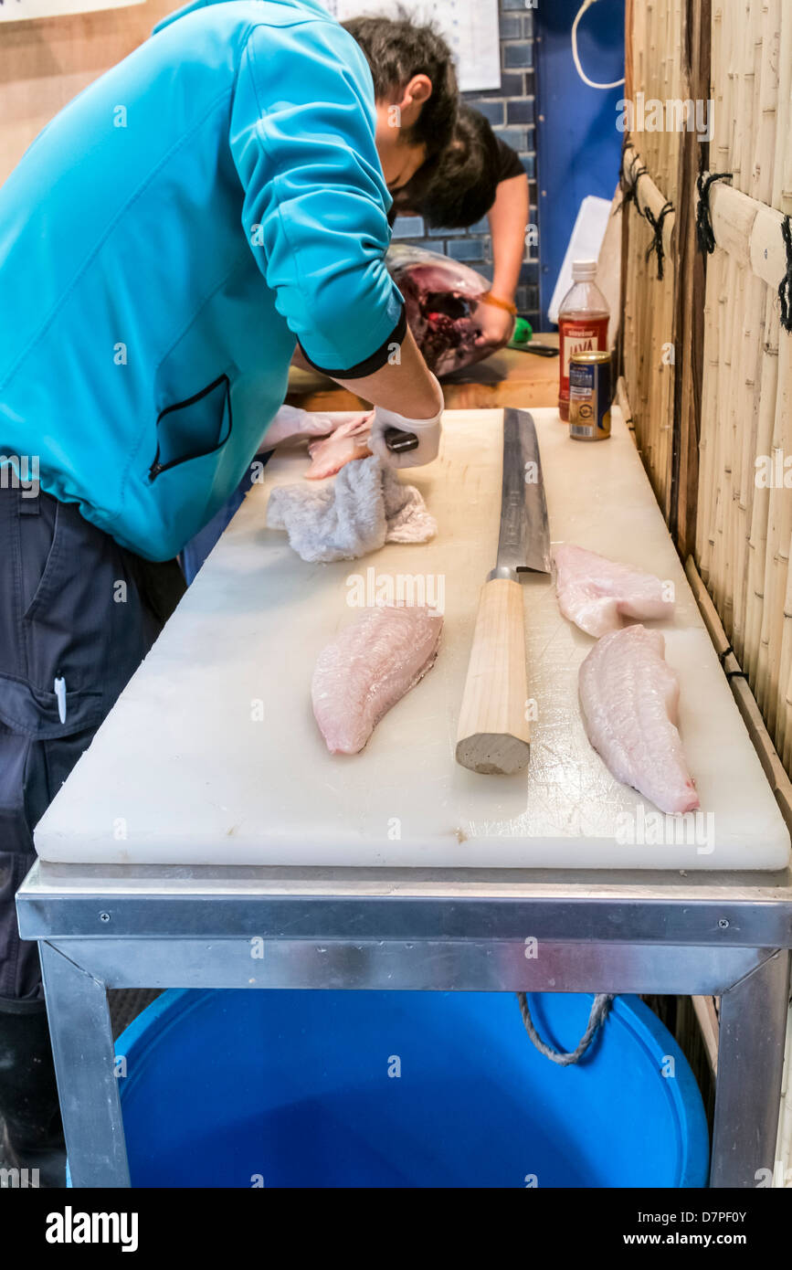 Fishmonger cuts fish for sale at the Tsukiji fish market, largest in