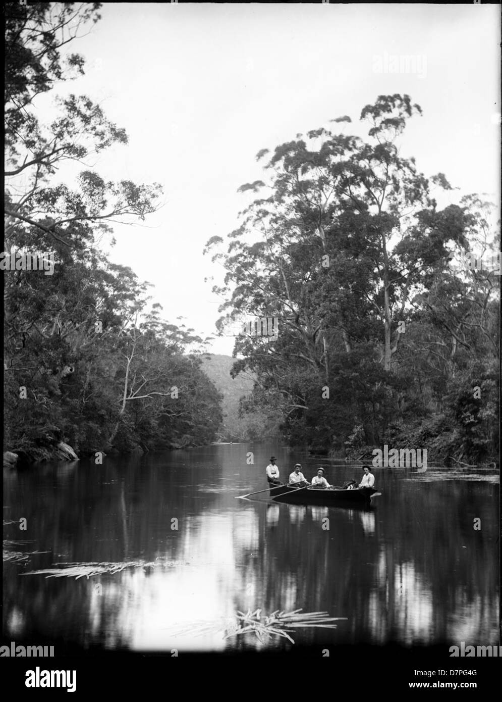 Early Human Rowing Raft A photograph captures four men in a rowing boat navigating a river, an ...