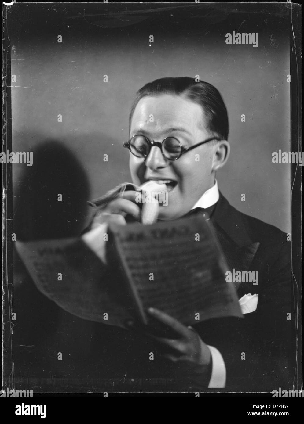 Man [Eric Sheldon?] eating banana and reading sheet music Stock Photo