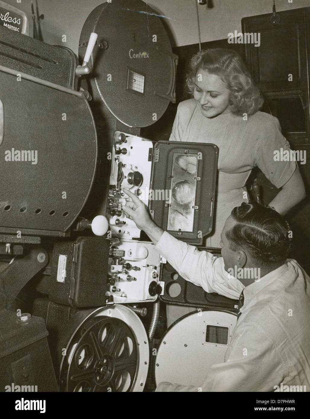 R.J. (Bob) Lucas and unidentified woman looking at a Centrex projector, 1940 - 1949 Stock Photo