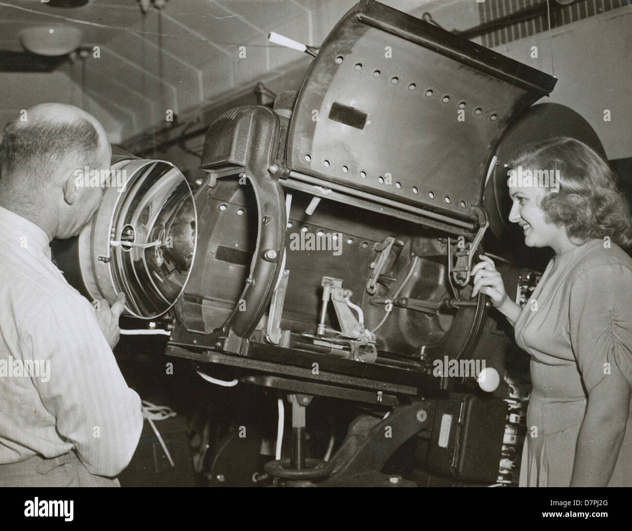 Harry Pike and unidentified woman looking at a Centrex projector, 1940 - 1949 Stock Photo
