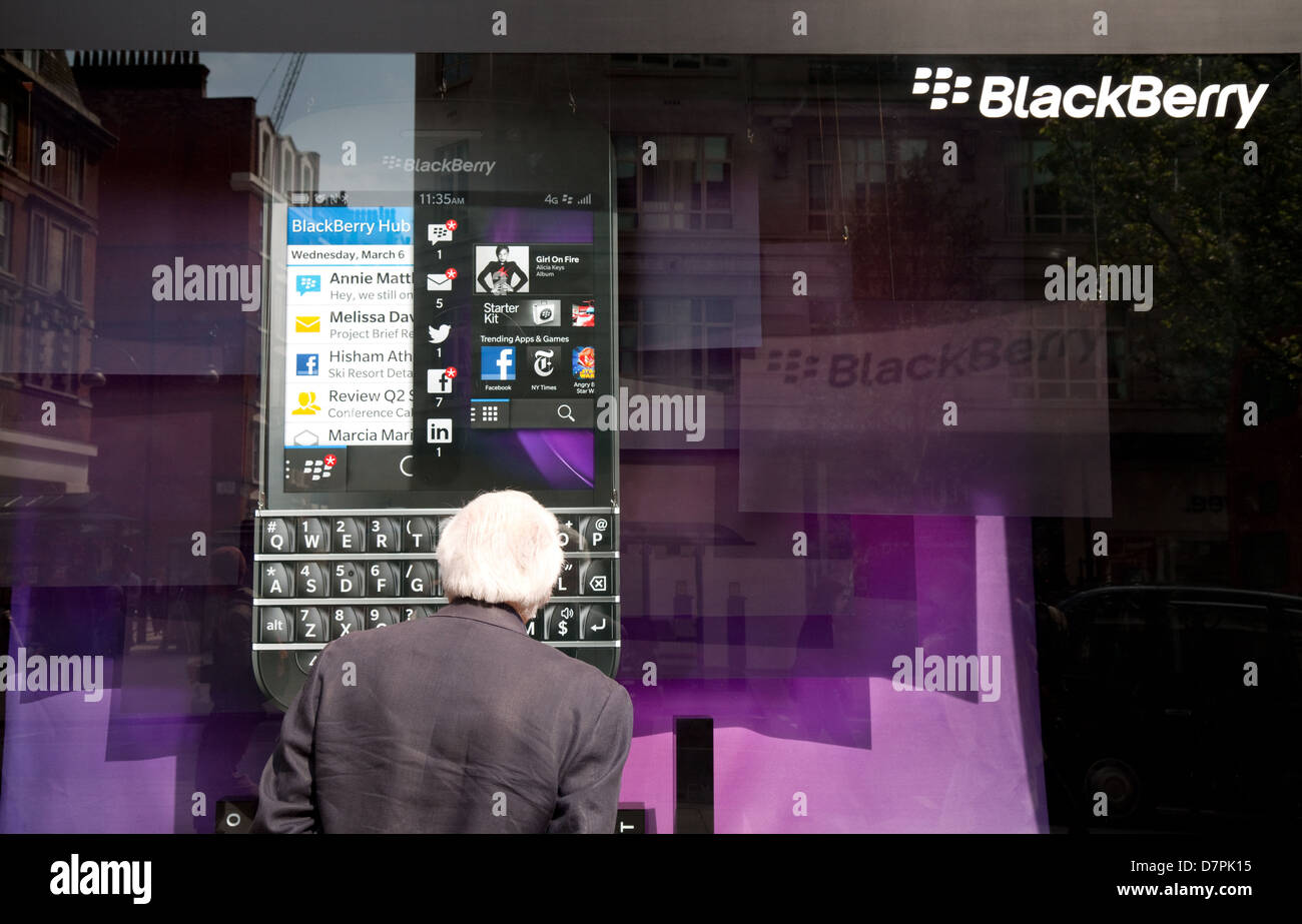 An elderly man looking in the window of the Blackberry store, Oxford street, central London, UK Stock Photo