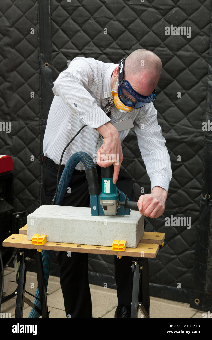 man demonstrating dust extraction on power tool Stock Photo