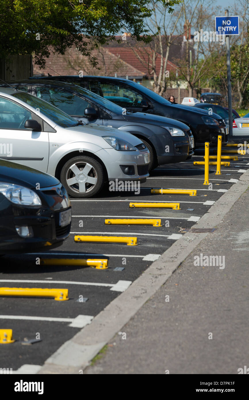 yellow locking parking bollards to protect residential car parking spaced Stock Photo