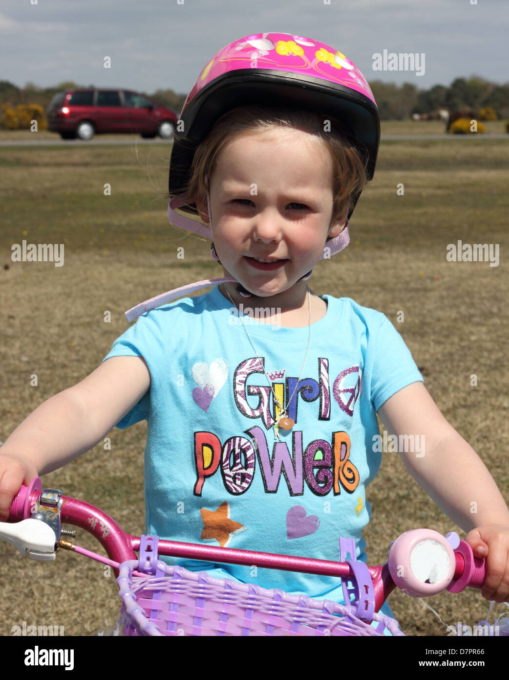 A young girl wearing her safety helmet while playing and riding her