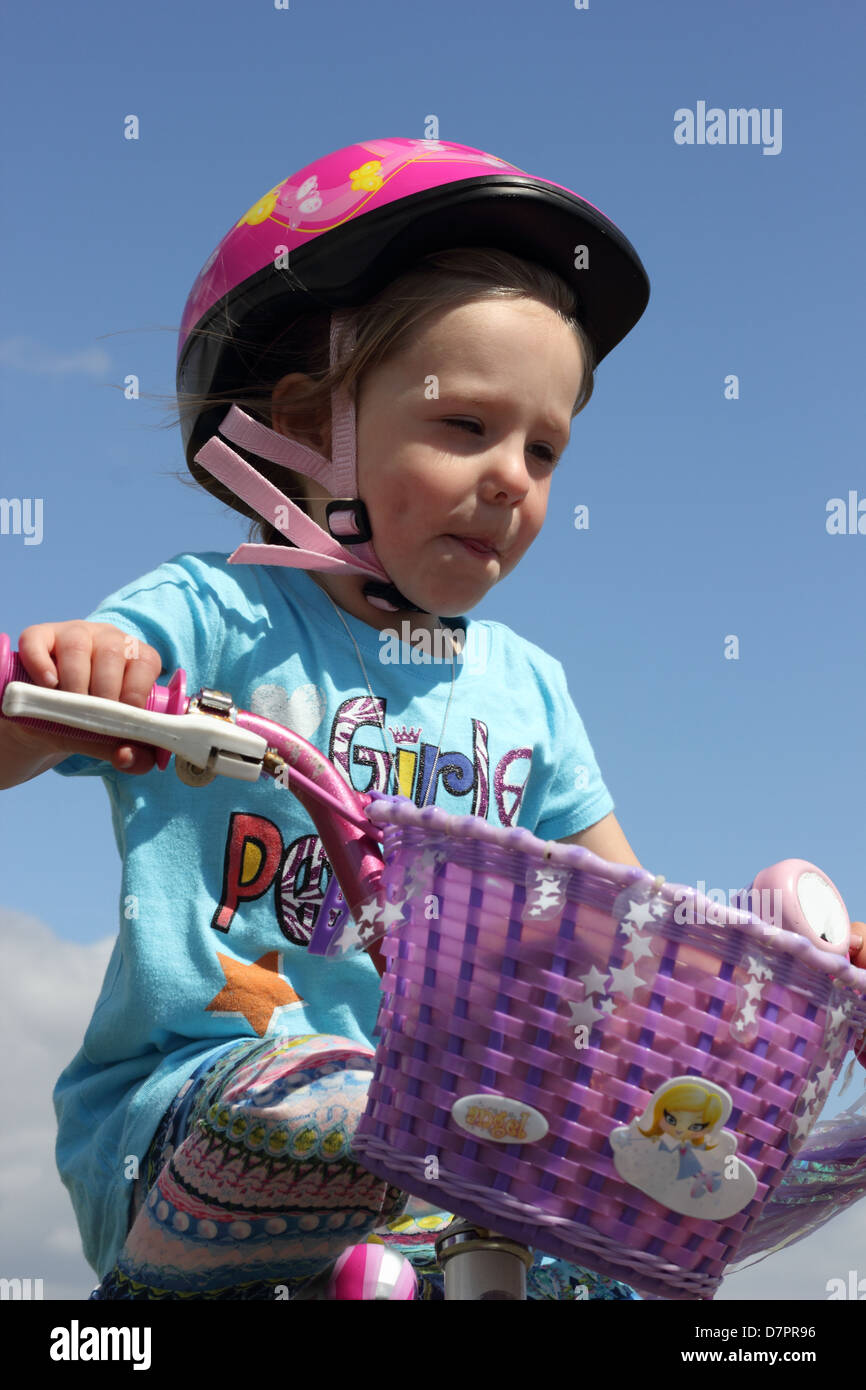 A young girl wearing her safety helmet while playing and riding her