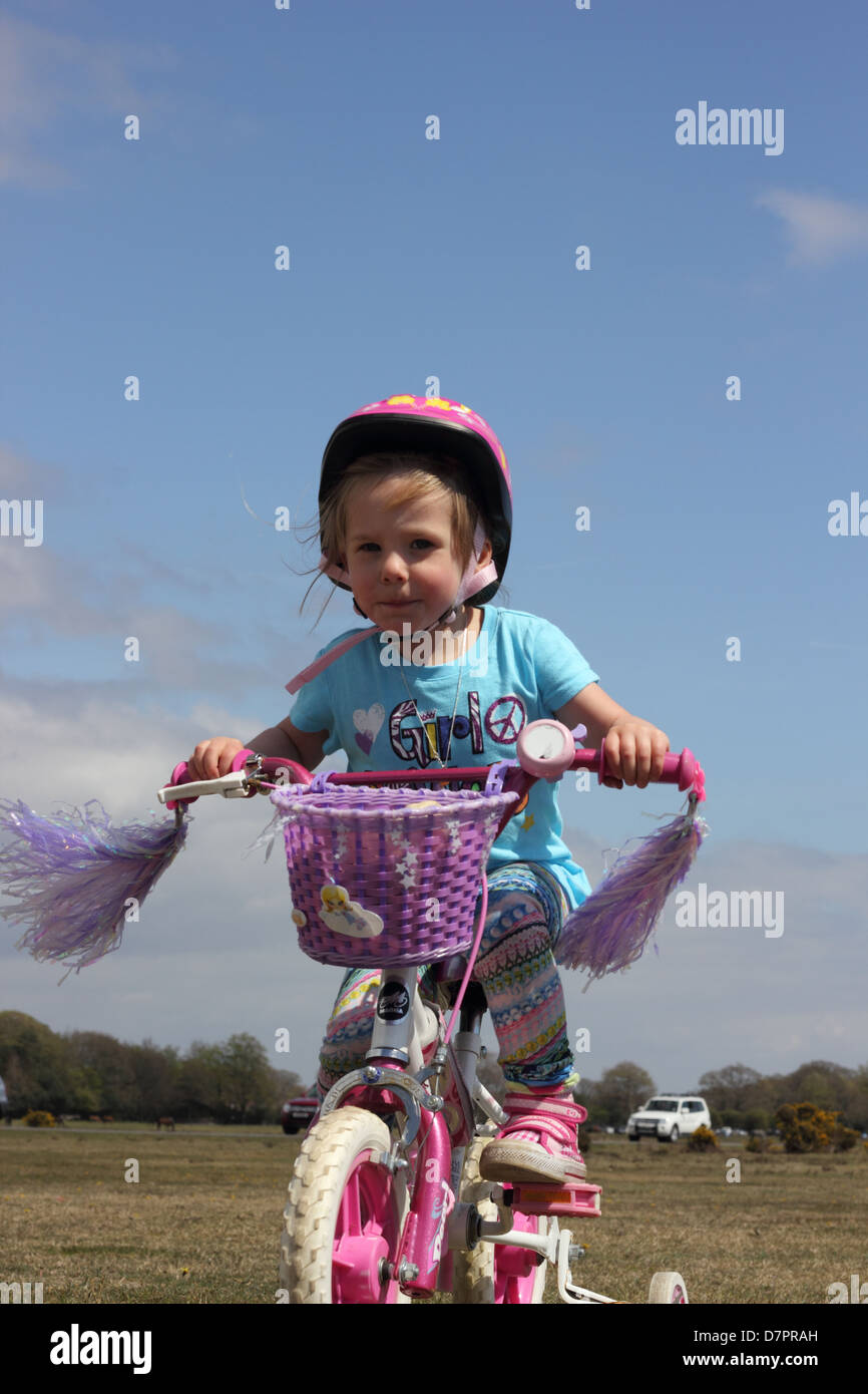 A young girl wearing her safety helmet while playing and riding her