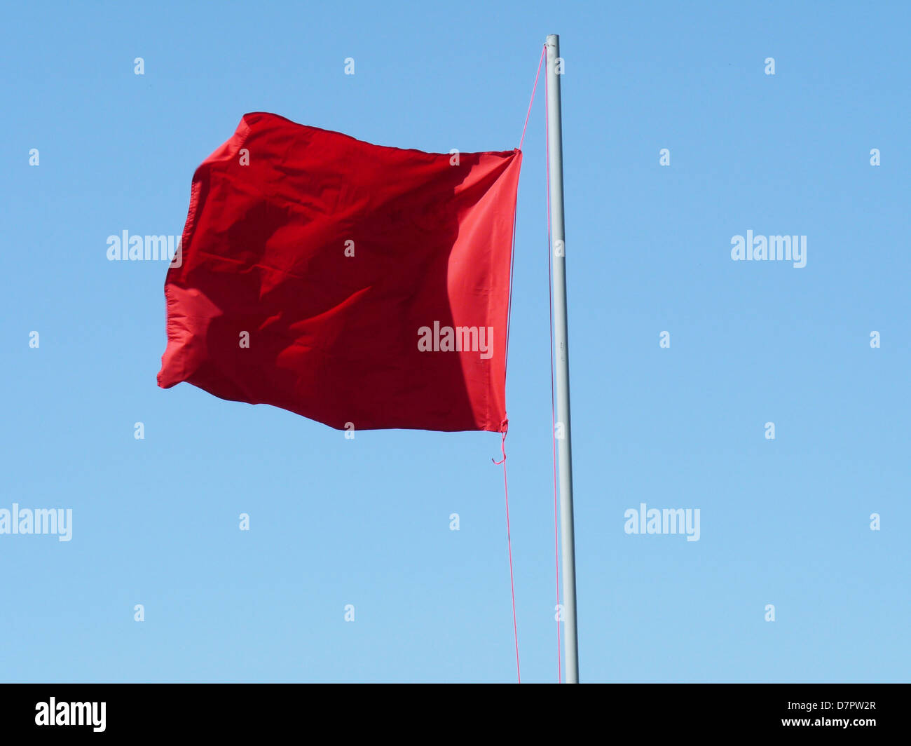 red flag communism totalitarian regime politics banner flag is raised unfreedom staff wind high day holiday blue azure sky crump Stock Photo