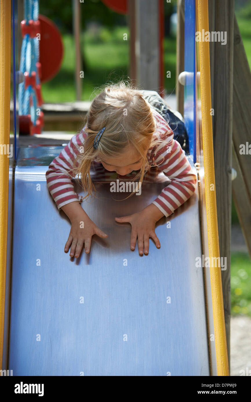 Child Blond Girl sliding slide on a playground Stock Photo Alamy