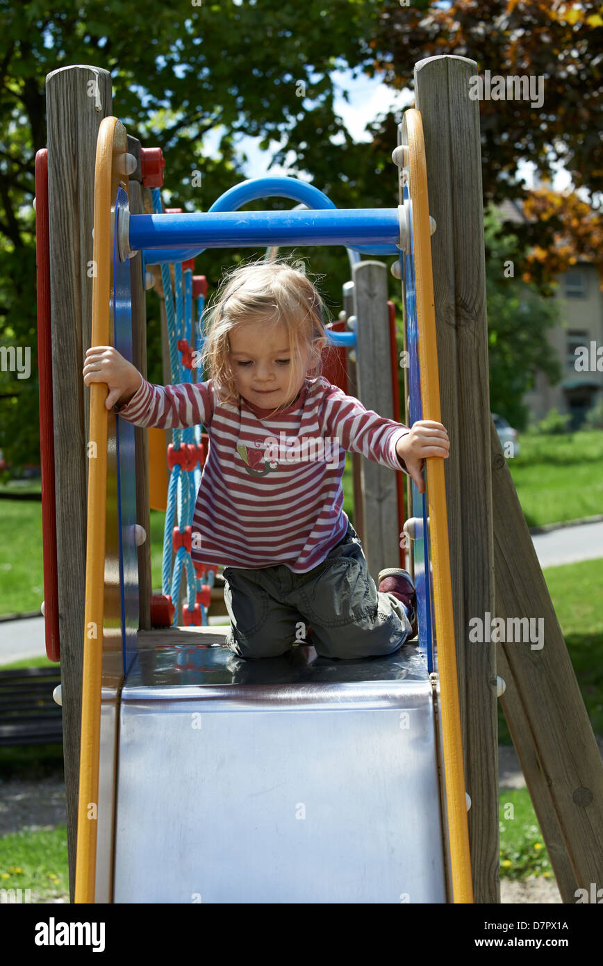 Child Blond Girl sliding slide on a playground Stock Photo Alamy