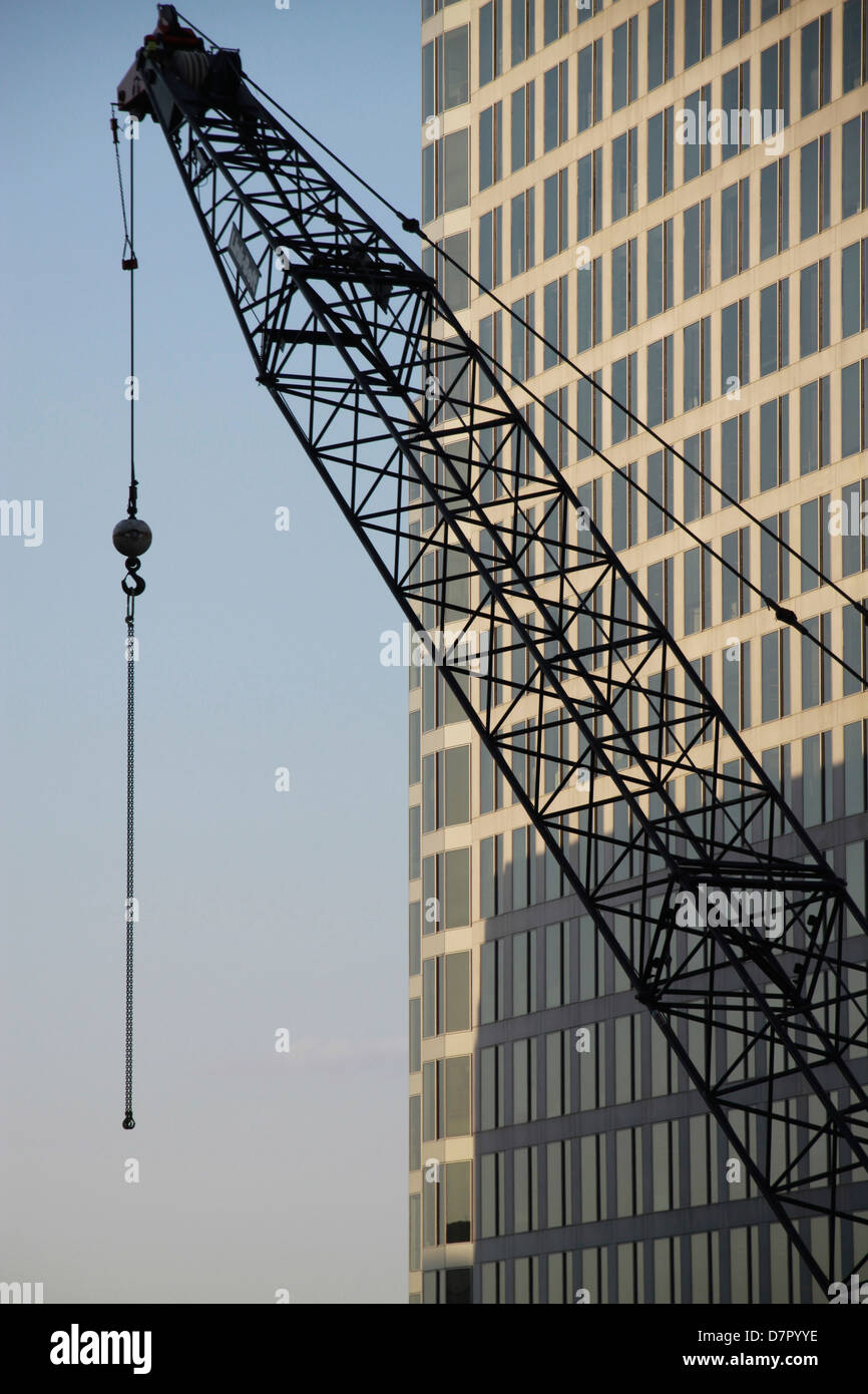 Construction crane erecting sky scraper. Stock Photo