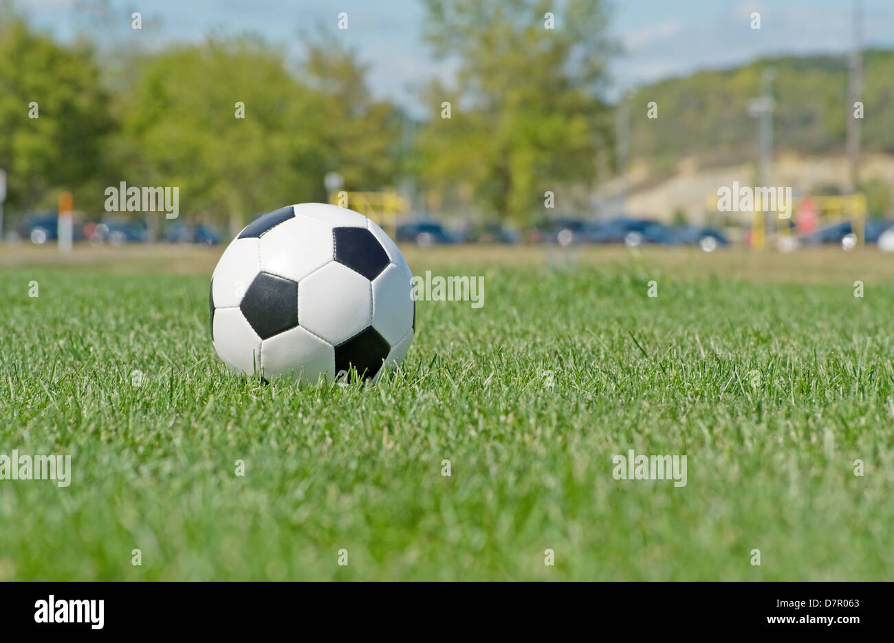 Soccer ball in the field with goal in background Stock Photo Alamy