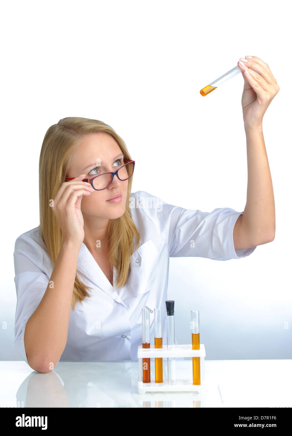 Young beautiful female scientist with flasks Stock Photo