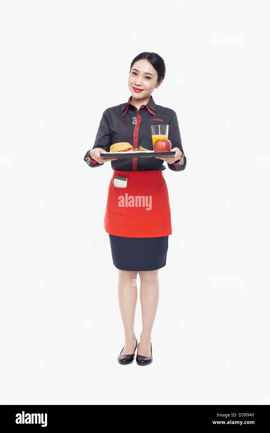 Young Waitress carrying tray with food, studio shot Stock Photo Alamy