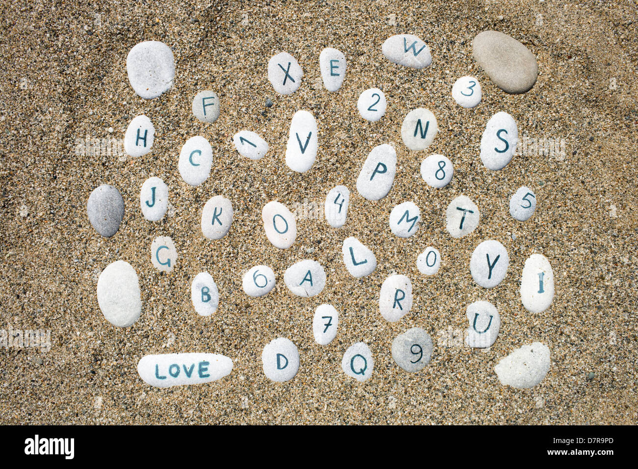 stones on a sand background, numbers and letters Stock Photo