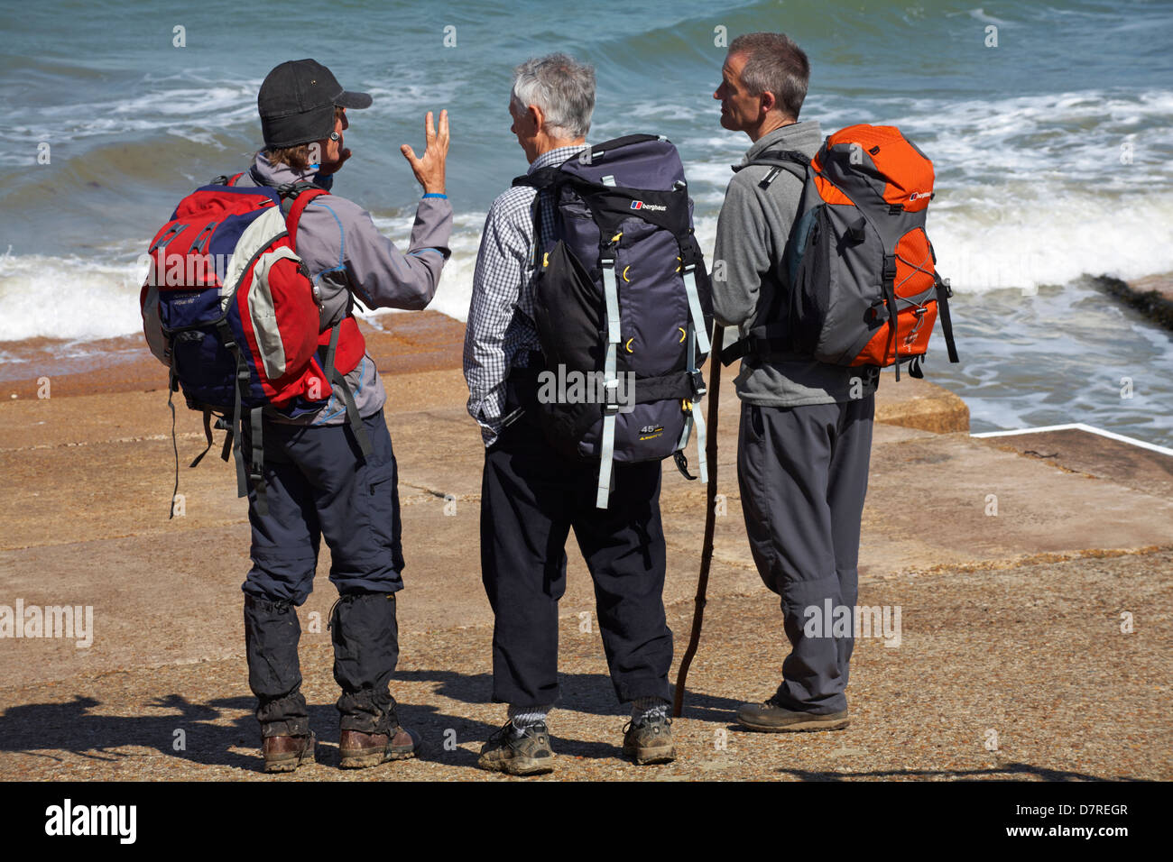 Three male walkers standing by the sea at Colwell Bay, Isle of Wight