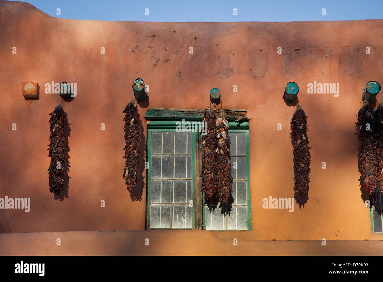 Chile ristras adorn a storefront along West Plaza Street which borders the Plaza in Taos, New Mexico. Stock Photo