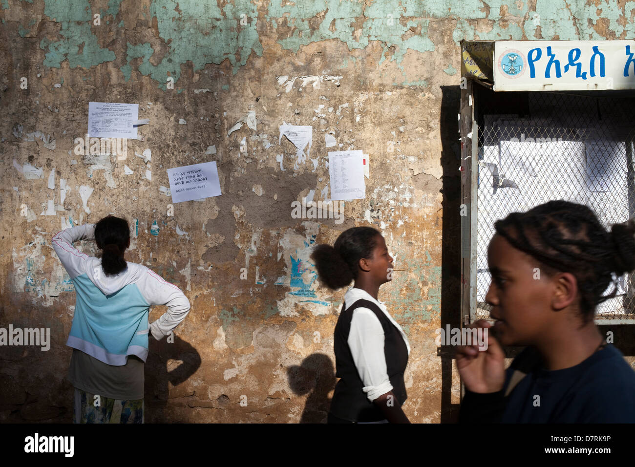 A woman looks at a poster advertising jobs on the street, Addis Ababa, Ethiopia. Stock Photo