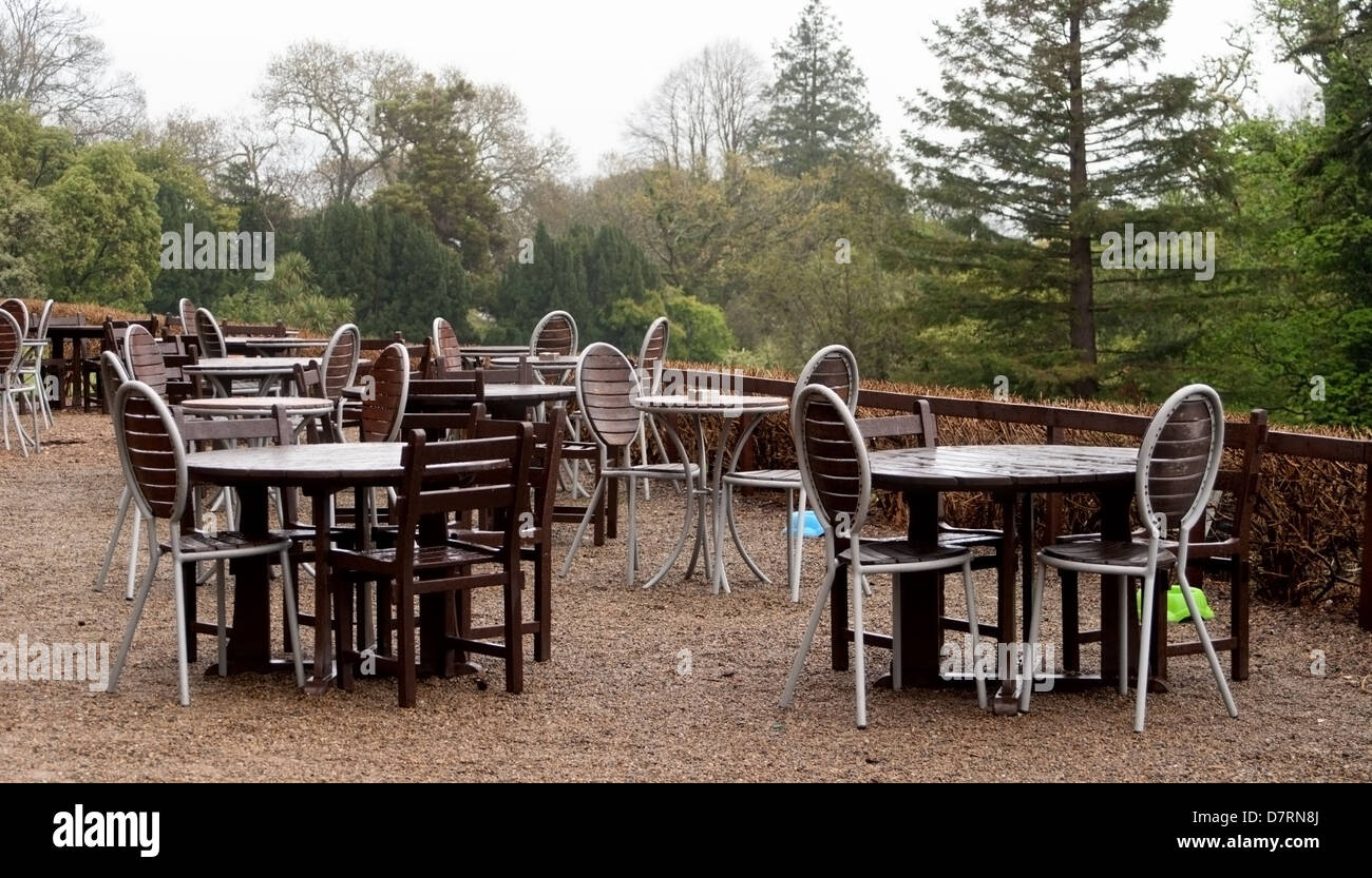 Closed outdoor cafe with wet tables and chairs Stock Photo