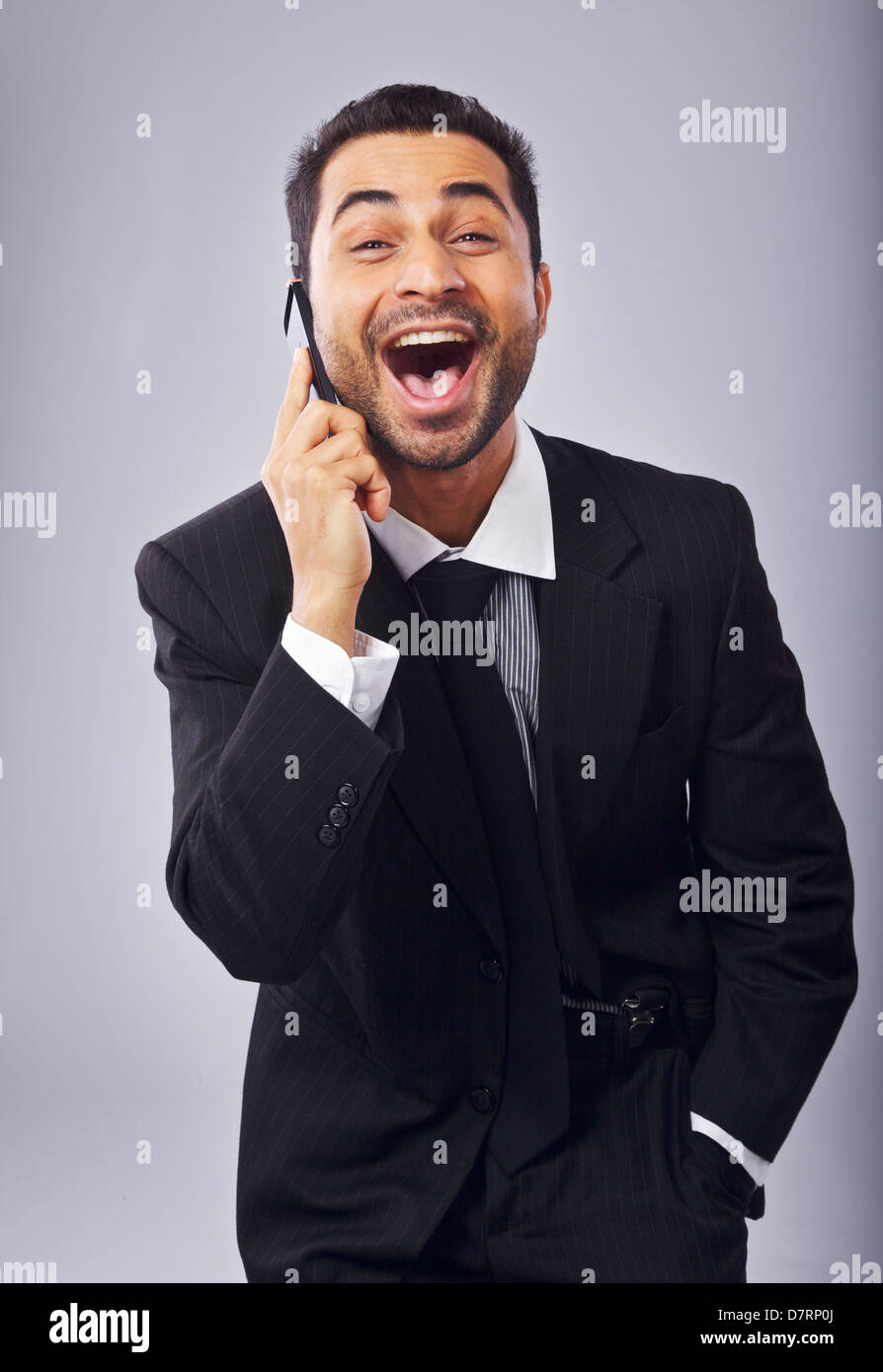 Ecstatic businessman with a cell phone excited about a good news Stock Photo