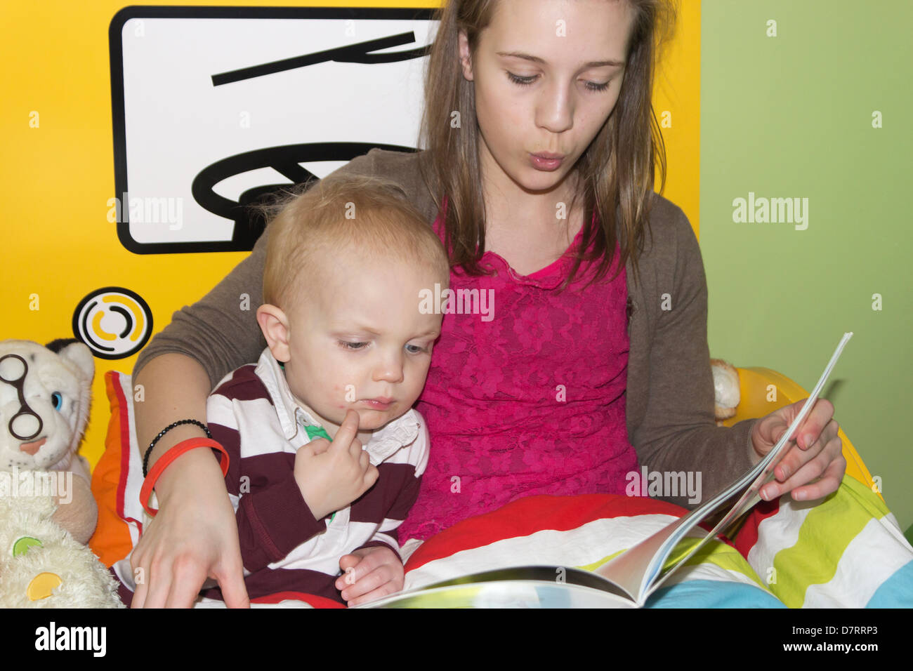 Young girl reading a story to a little boy. Stock Photo