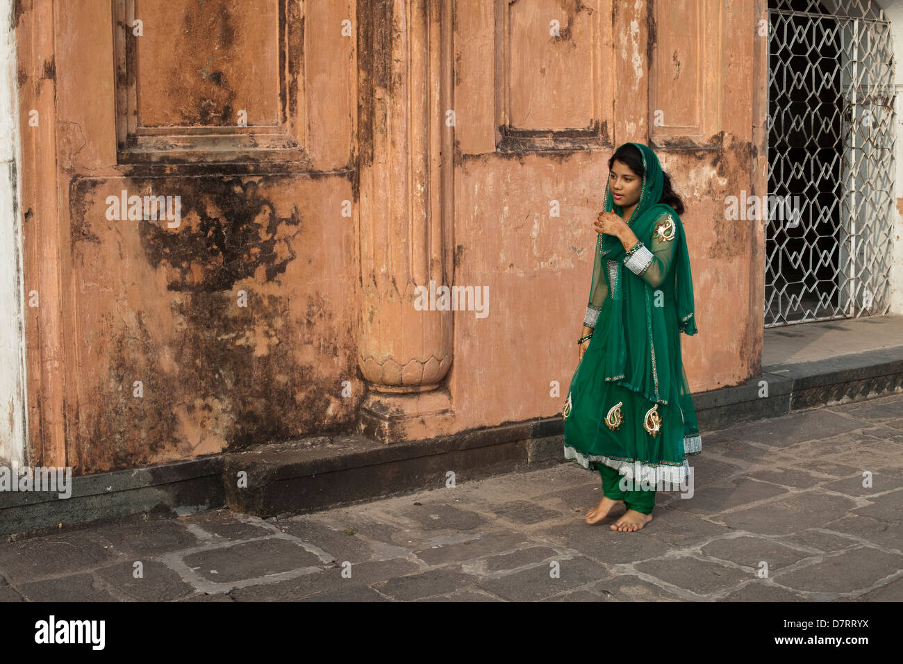A young Muslim woman walks past the Tomb of Bibi Pari in Lalbagh Fort in Dhaka, Bangladesh Stock Photo