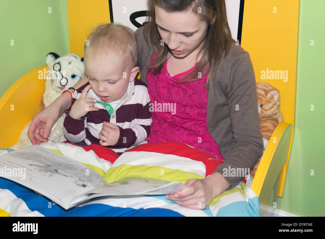 Young girl reading a story to a little boy. Stock Photo