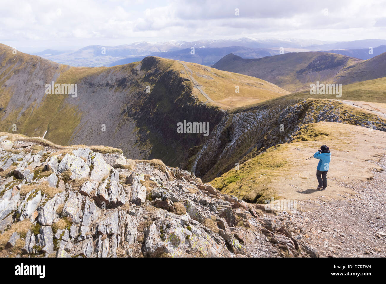 A hiker taking in the view towards Hobcarton with Grisedale Pike just out of shot. The Lake District. Stock Photo