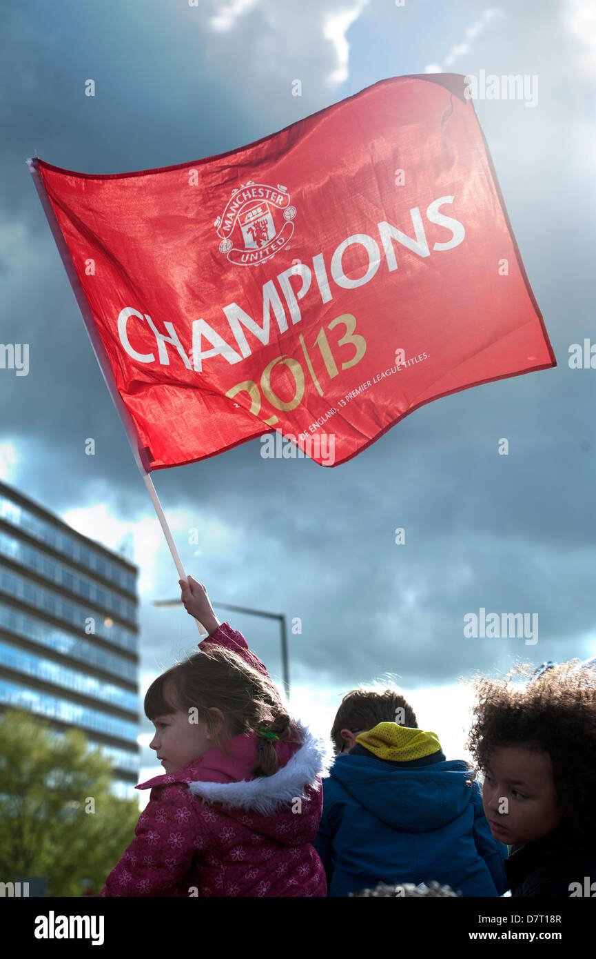 Manchester, UK. 13th May, 2013. girl holds aloft a manchester united champions flag at the victory parade for the 20th league trophy in 2013 manchester england Credit: Lee Avison/Alamy Live News Stock Photo