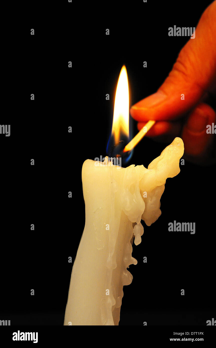 Woman lighting a candle with a match Stock Photo Alamy