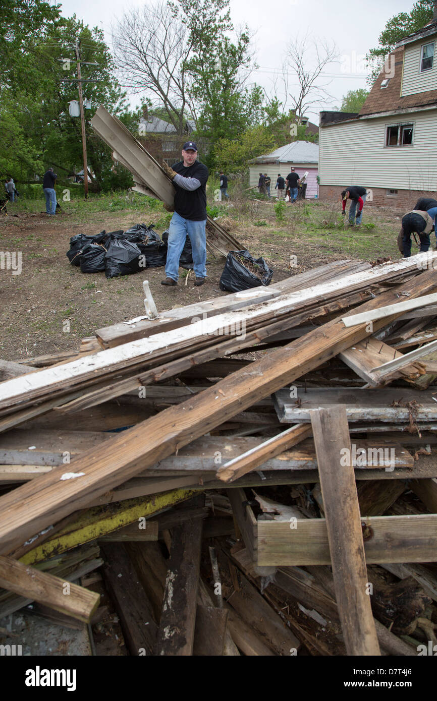 Volunteers from Chrysler Corp. and the Creekside neighborhood clean debris from vacant property in Detroit. Stock Photo