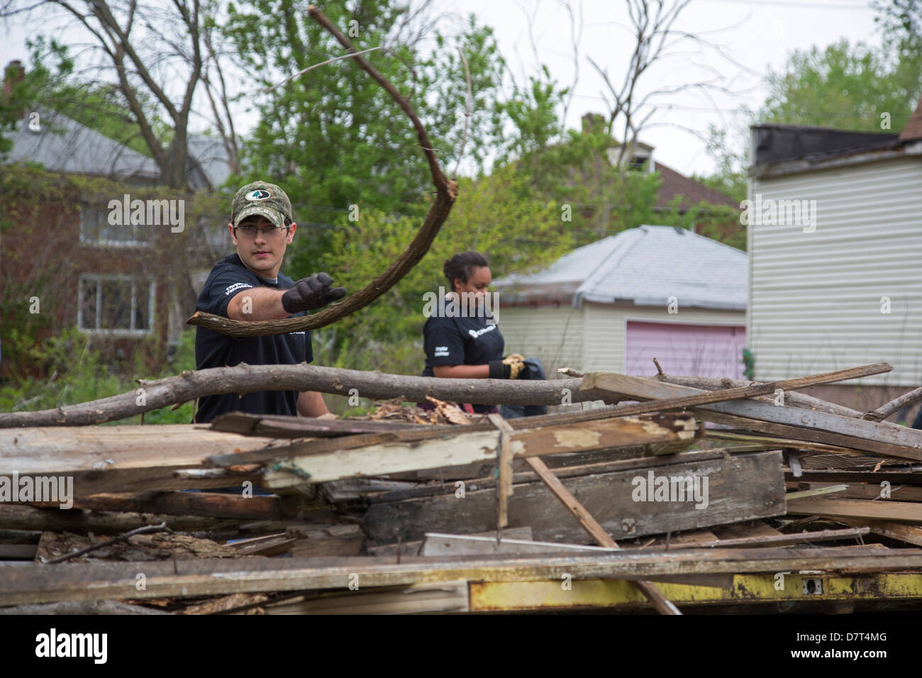 Volunteers from Chrysler Corp. and the Creekside neighborhood clean debris from vacant property in Detroit. Stock Photo