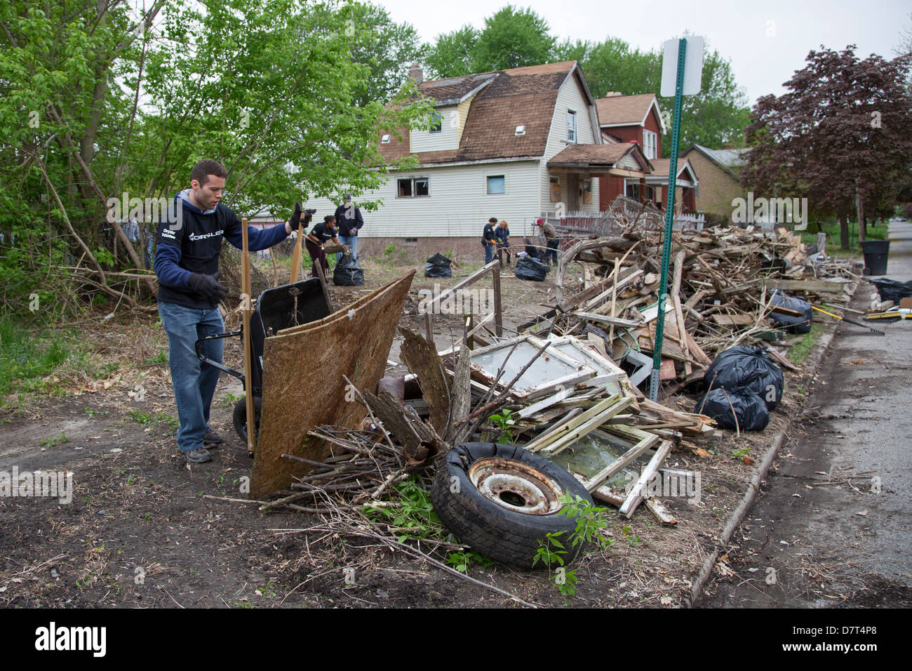 Volunteers from Chrysler Corp. and the Creekside neighborhood clean debris from vacant property in Detroit. Stock Photo