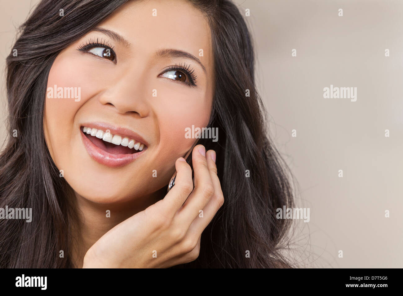 Portrait of a beautiful happy young Chinese Asian Oriental woman talking on her cell phone Stock Photo