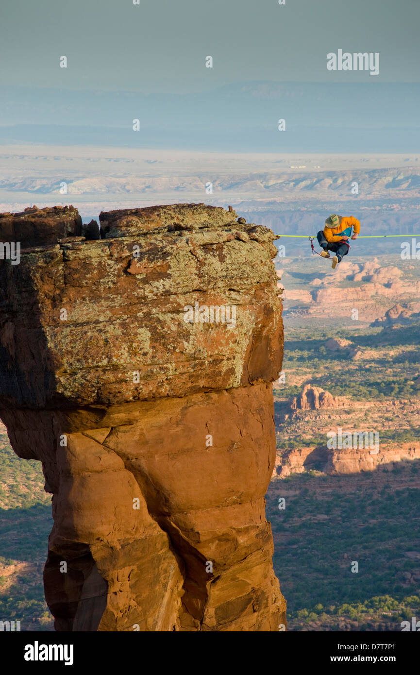 Larry Harpe highlining (slacklining) between Navaho Sandstone Towers on BLM land near Moab, Utah. (MR) Stock Photo