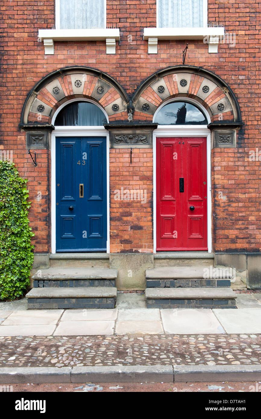 two original 18th doors side by side one red the other blue Stock Photo