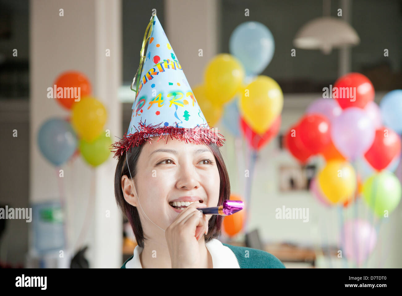 Young Woman Blowing Party Horn Stock Photo - Alamy