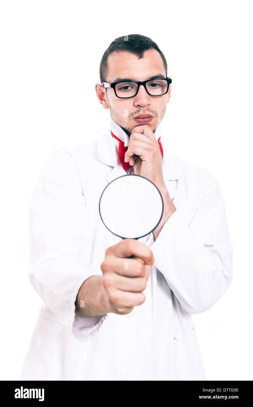 Serious scientist in lab coat looking at magnifying glass, isolated on white background Stock Photo