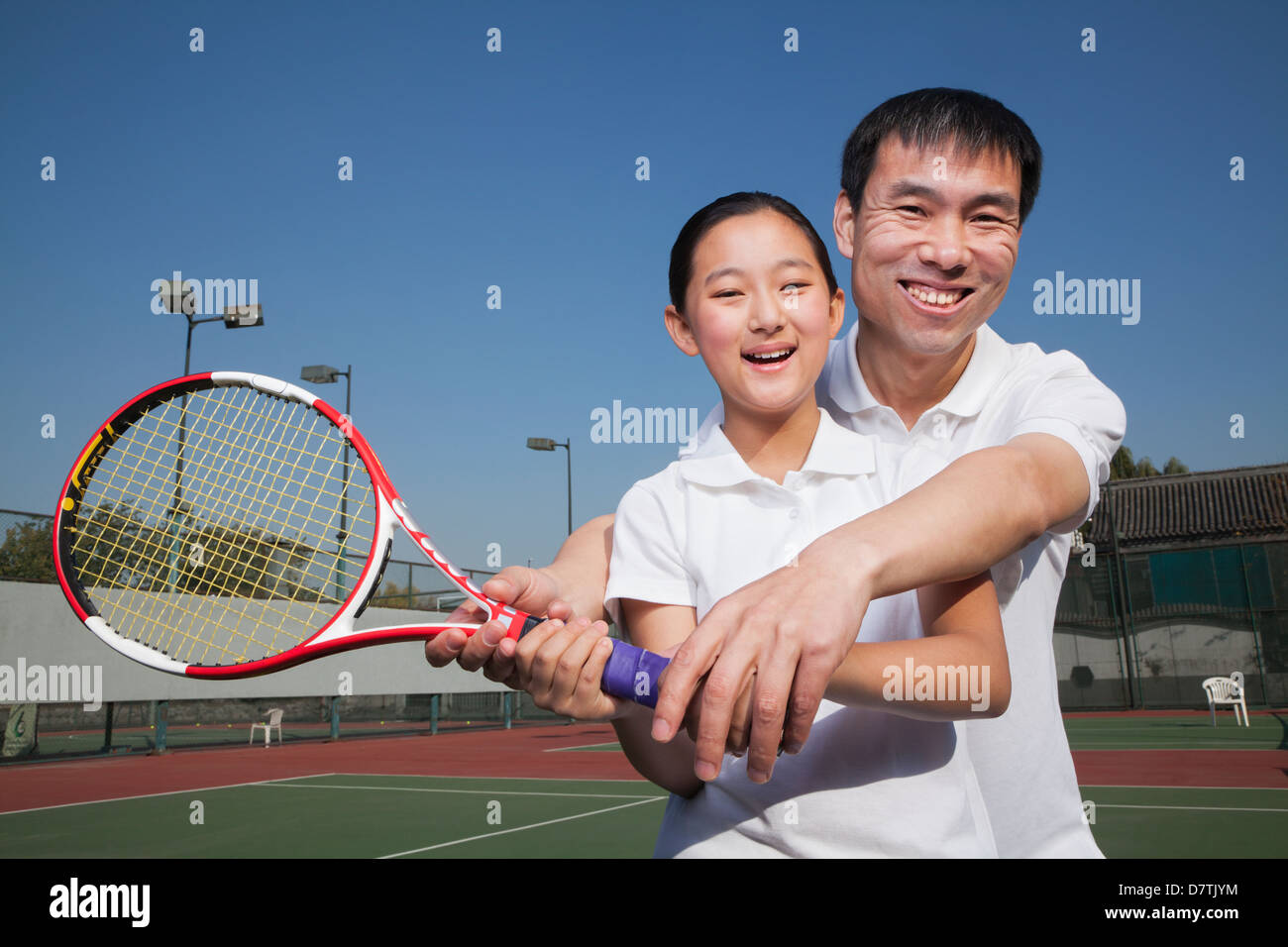 Young girl playing tennis with her coach Stock Photo