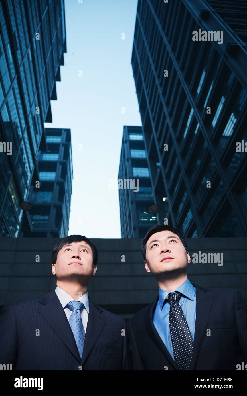 Two businessmen standing side by side outdoors, Beijing Stock Photo - Alamy